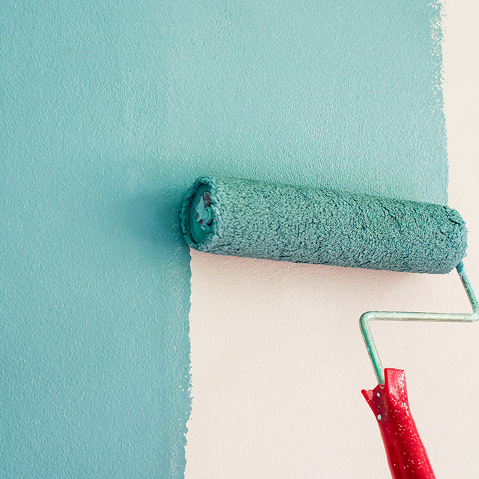paint roller close up painting house wall in light blue color indianapolis in